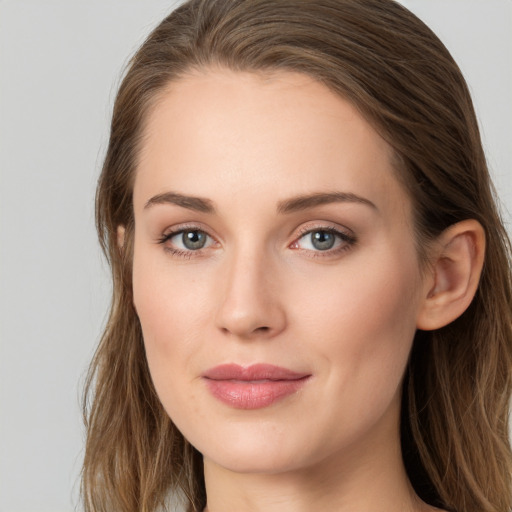 Joyful white young-adult female with long  brown hair and blue eyes