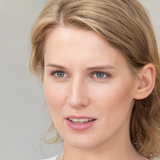 Joyful white young-adult female with medium  brown hair and blue eyes