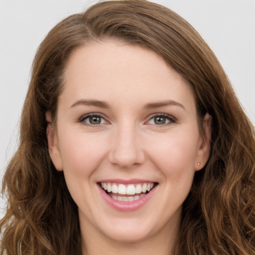 Joyful white young-adult female with long  brown hair and green eyes