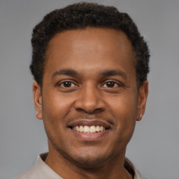 Joyful latino young-adult male with short  brown hair and brown eyes