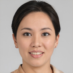 Joyful asian young-adult female with short  brown hair and brown eyes