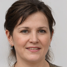 Joyful white adult female with medium  brown hair and grey eyes