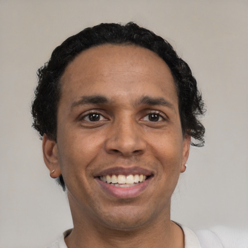 Joyful black adult male with short  black hair and brown eyes