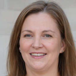 Joyful white adult female with long  brown hair and grey eyes