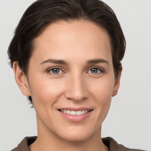 Joyful white young-adult female with short  brown hair and grey eyes