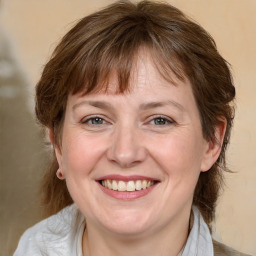 Joyful white adult female with medium  brown hair and grey eyes