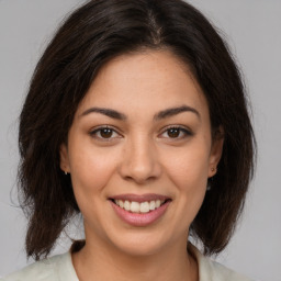 Joyful latino young-adult female with medium  brown hair and brown eyes