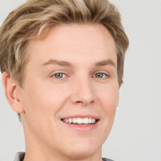 Joyful white young-adult male with short  brown hair and blue eyes