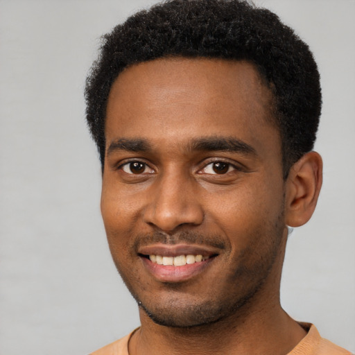 Joyful black young-adult male with short  black hair and brown eyes