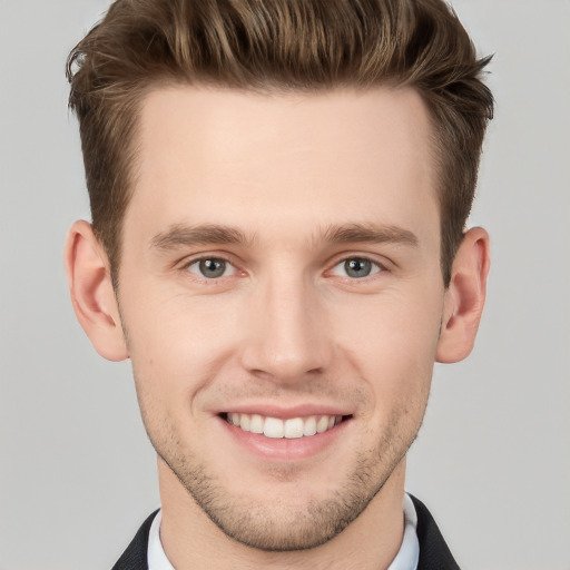 Joyful white young-adult male with short  brown hair and grey eyes