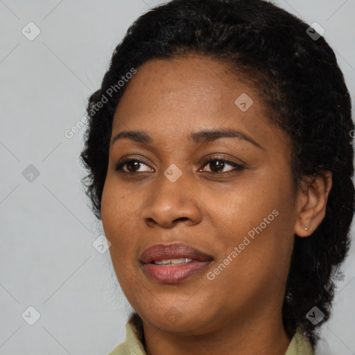 Joyful black young-adult female with long  black hair and brown eyes