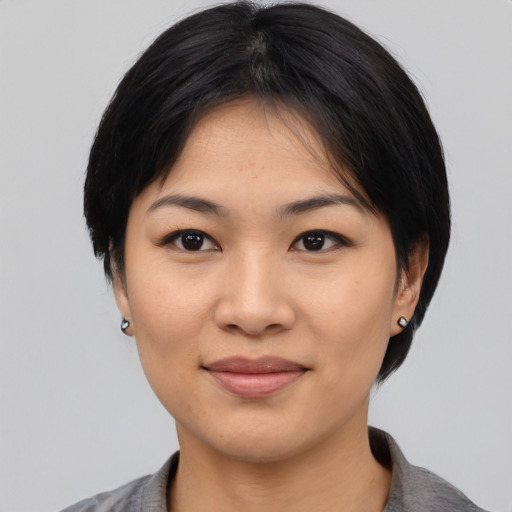 Joyful asian young-adult female with medium  black hair and brown eyes
