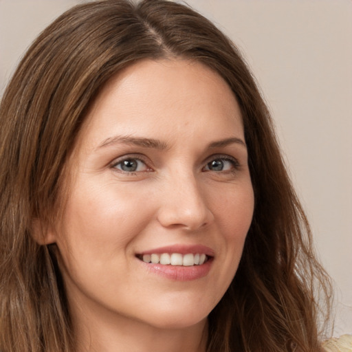 Joyful white young-adult female with long  brown hair and grey eyes