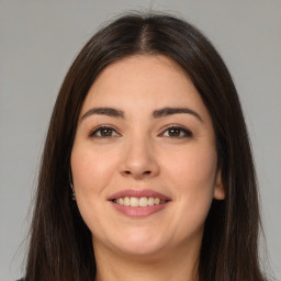 Joyful white young-adult female with long  brown hair and brown eyes