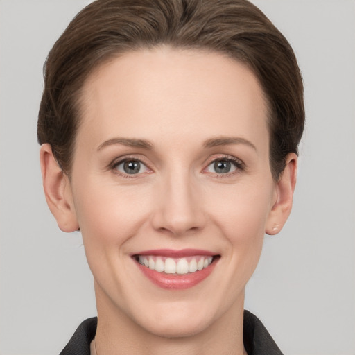 Joyful white young-adult female with short  brown hair and grey eyes