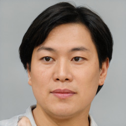 Joyful asian adult male with short  brown hair and brown eyes