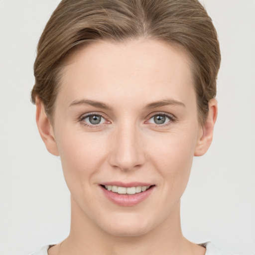 Joyful white young-adult female with short  brown hair and grey eyes