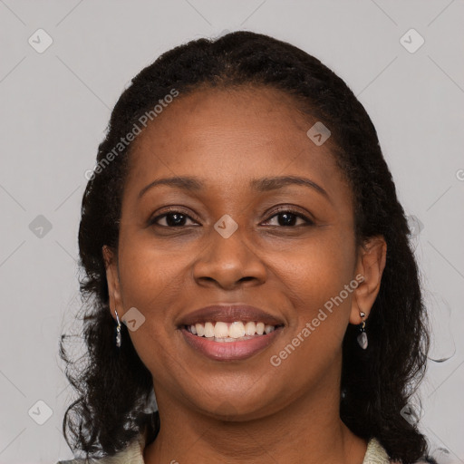 Joyful black young-adult female with long  brown hair and brown eyes