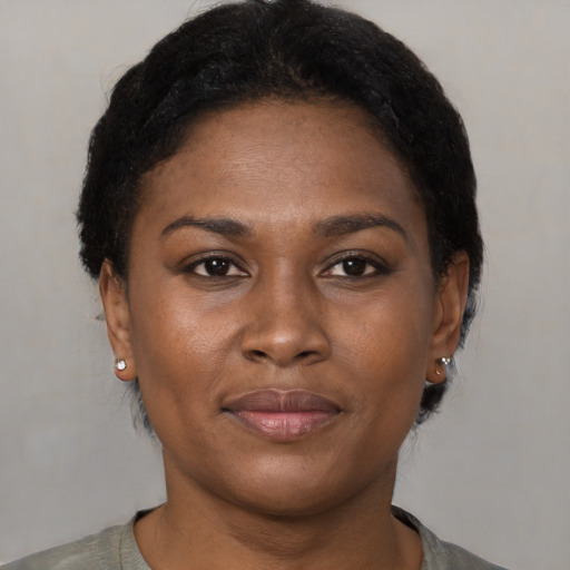 Joyful black young-adult female with short  brown hair and brown eyes