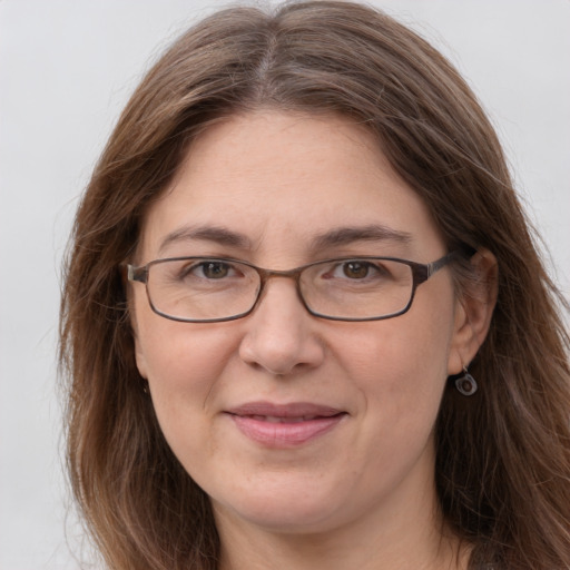 Joyful white adult female with long  brown hair and grey eyes