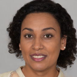 Joyful black young-adult female with medium  brown hair and brown eyes
