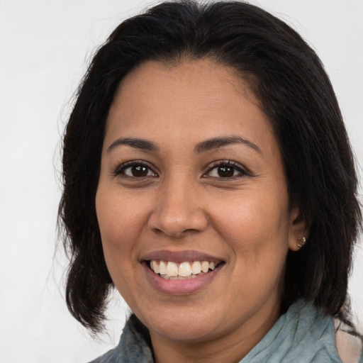 Joyful latino young-adult female with medium  brown hair and brown eyes