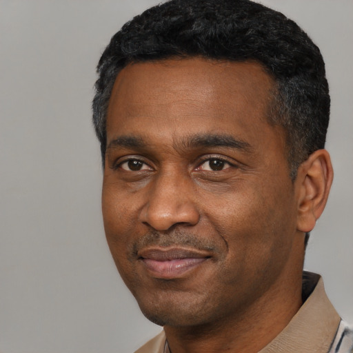 Joyful black adult male with short  black hair and brown eyes