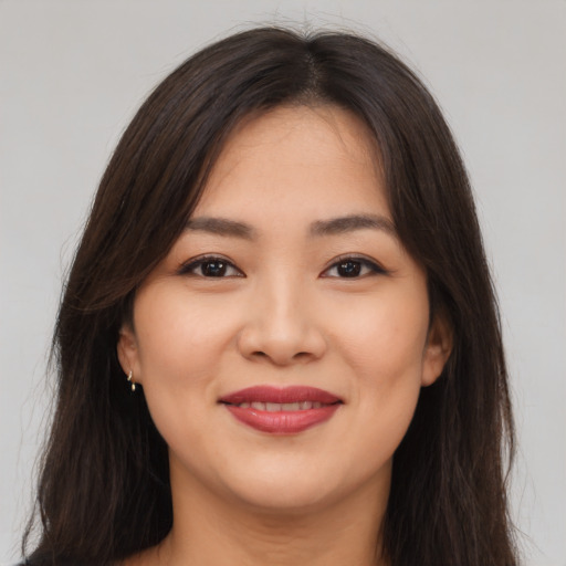 Joyful asian young-adult female with long  brown hair and brown eyes