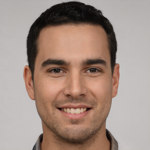 Joyful white young-adult male with short  black hair and brown eyes