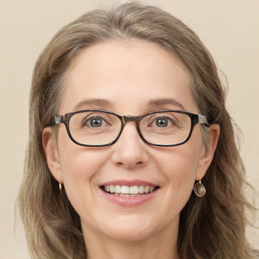 Joyful white adult female with long  brown hair and blue eyes