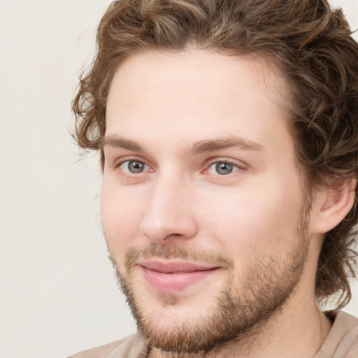 Joyful white young-adult male with short  brown hair and green eyes