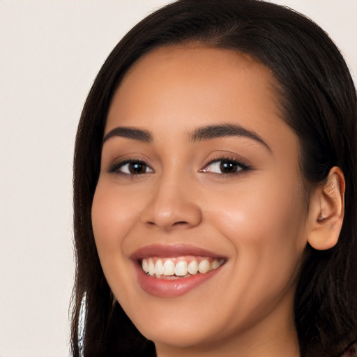 Joyful latino young-adult female with long  brown hair and brown eyes