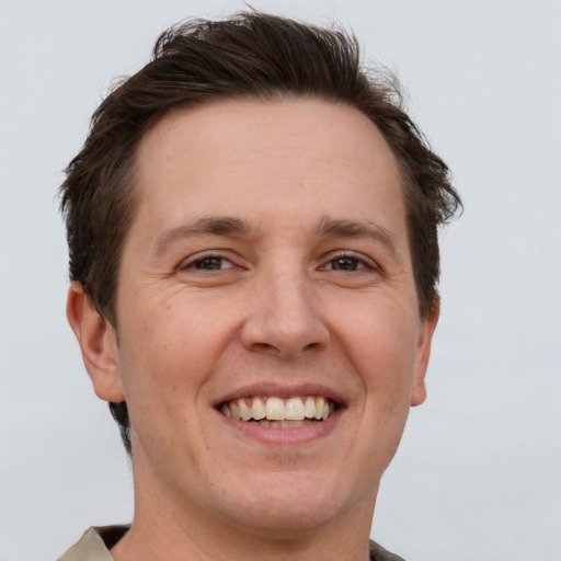 Joyful white adult male with short  brown hair and grey eyes