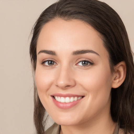 Joyful white young-adult female with long  brown hair and brown eyes