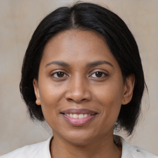 Joyful black adult female with medium  black hair and brown eyes