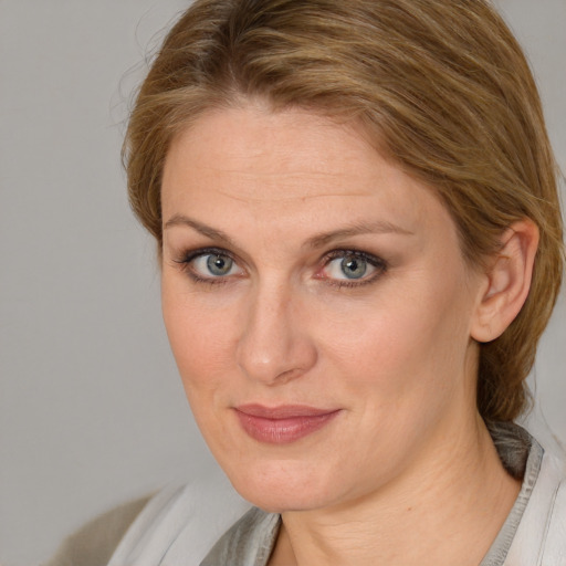 Joyful white adult female with medium  brown hair and blue eyes