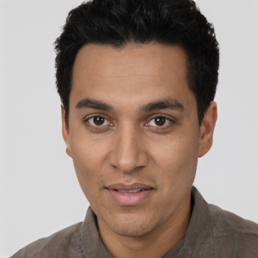 Joyful latino young-adult male with short  black hair and brown eyes