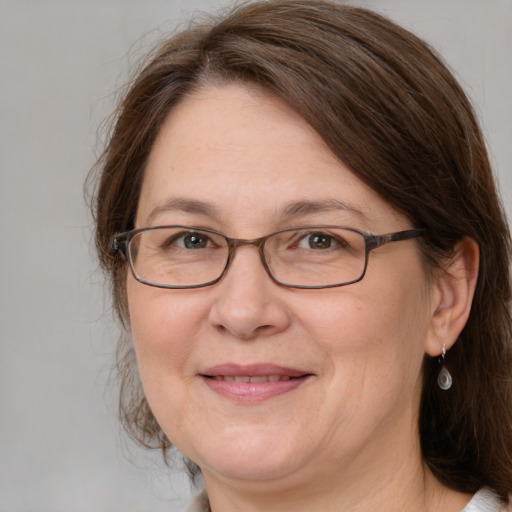 Joyful white adult female with medium  brown hair and grey eyes