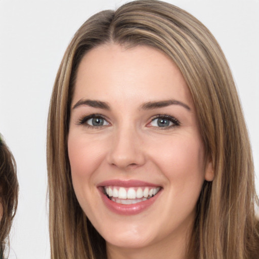 Joyful white young-adult female with long  brown hair and brown eyes