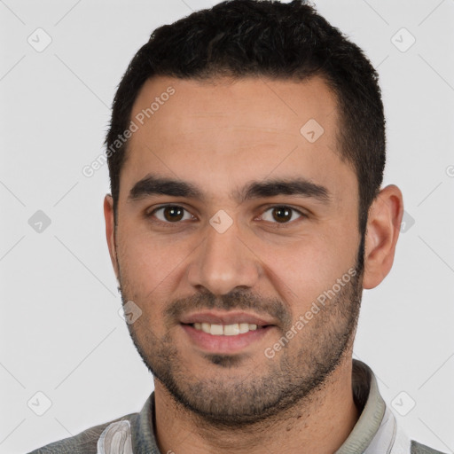 Joyful white young-adult male with short  black hair and brown eyes