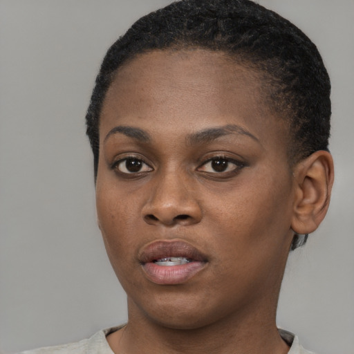 Joyful black young-adult female with short  black hair and brown eyes