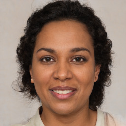 Joyful black adult female with medium  brown hair and brown eyes