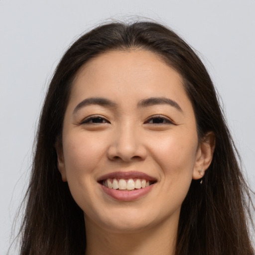 Joyful latino young-adult female with long  brown hair and brown eyes