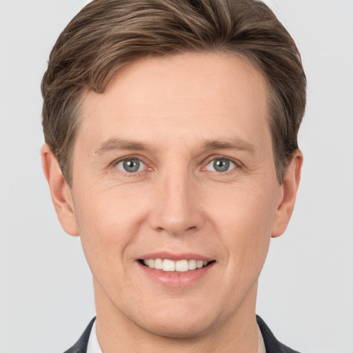 Joyful white young-adult male with short  brown hair and grey eyes