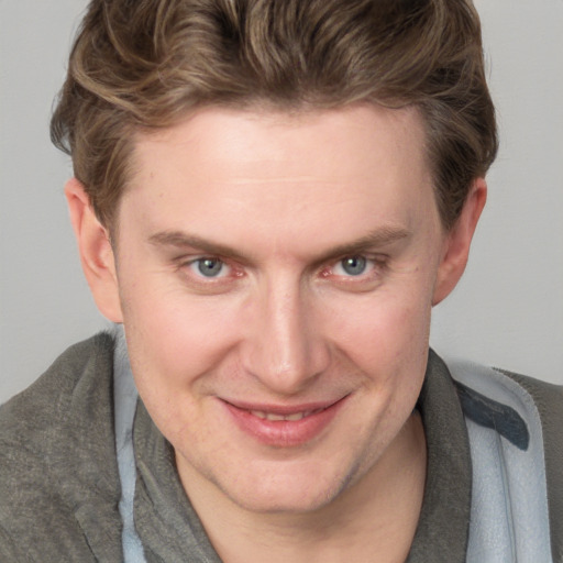 Joyful white adult male with short  brown hair and blue eyes