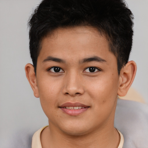 Joyful asian young-adult male with short  brown hair and brown eyes