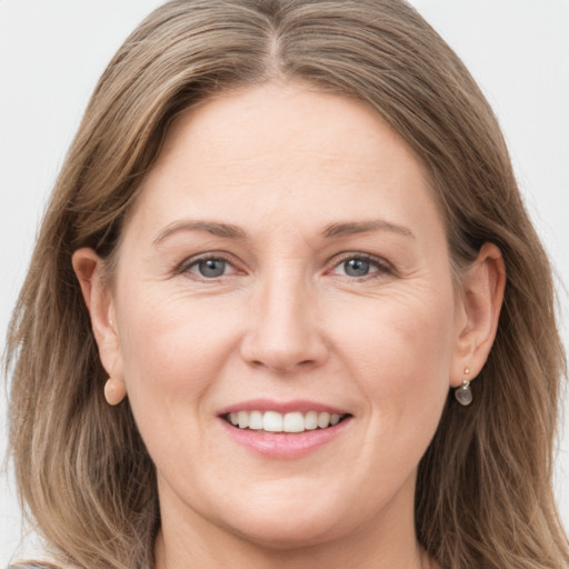 Joyful white adult female with long  brown hair and grey eyes