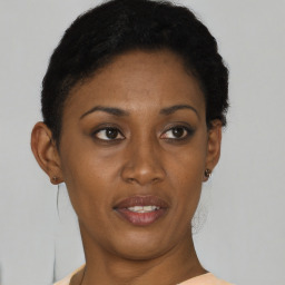 Joyful black young-adult female with short  brown hair and brown eyes