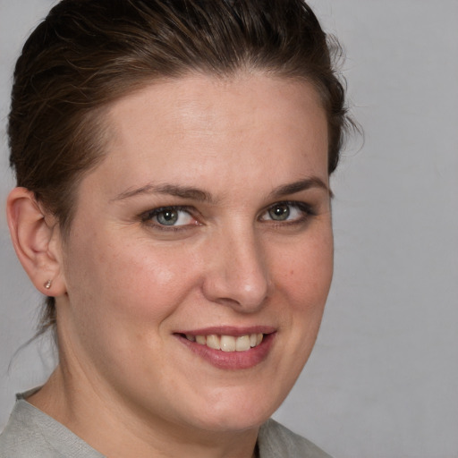 Joyful white young-adult female with medium  brown hair and blue eyes