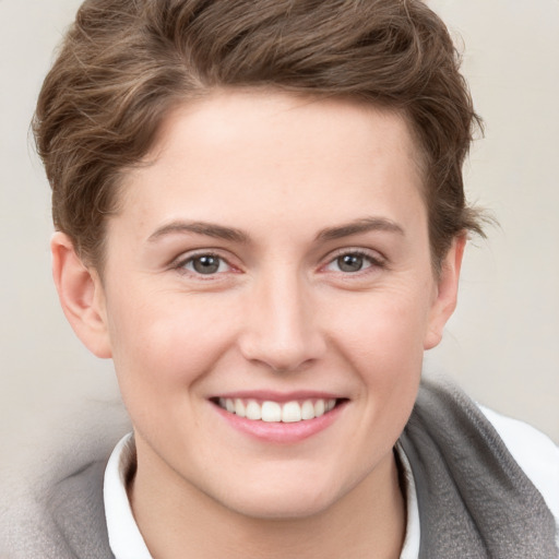 Joyful white young-adult female with short  brown hair and grey eyes